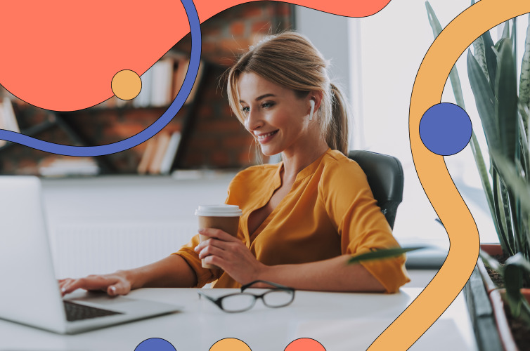 Woman drinking a coffee and working on her laptop while smiling