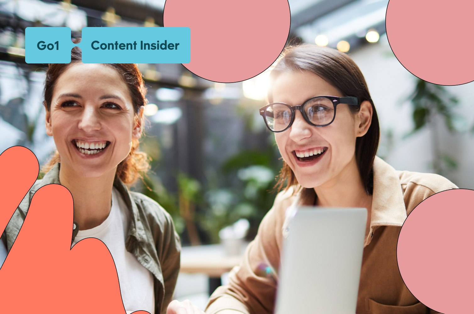 Two women working collaboratively with a laptop and big smiles